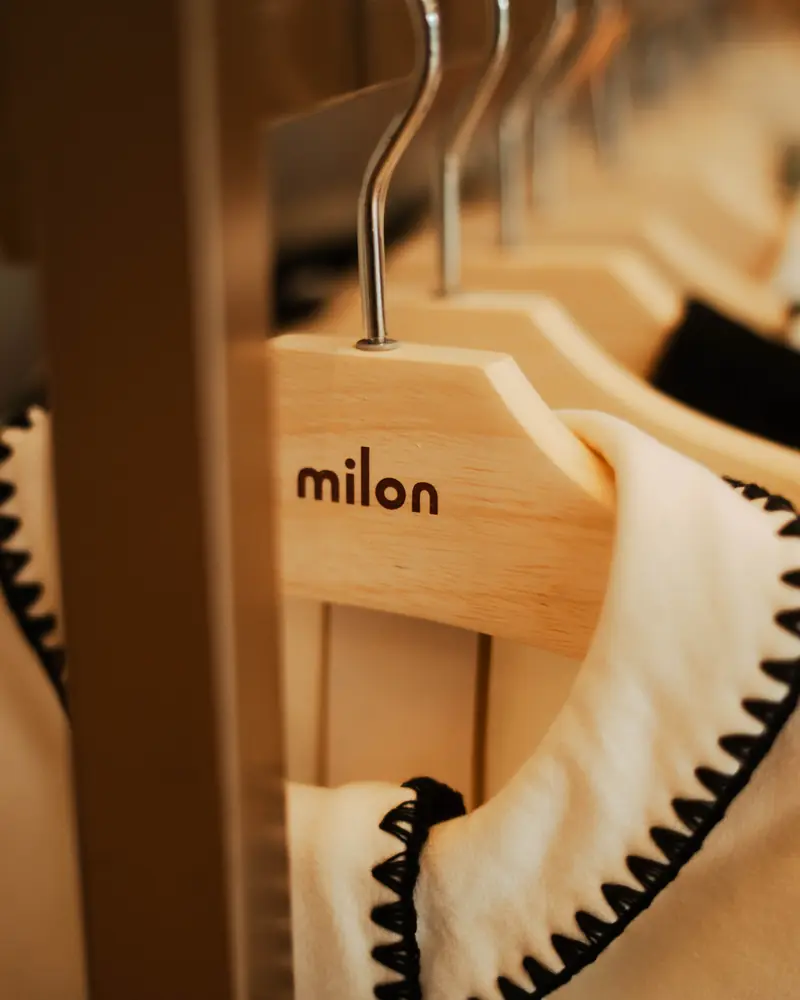 Cabides com a marca Milon e peças da coleção